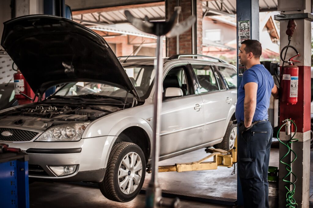 Car mechanic working in a repair garage with a two post lift -  2 post lift placement | 2 post lift layout