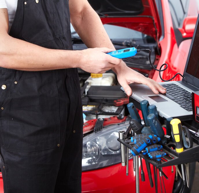 mechanic standing next to a tool chest filled with essential auto repair equipment