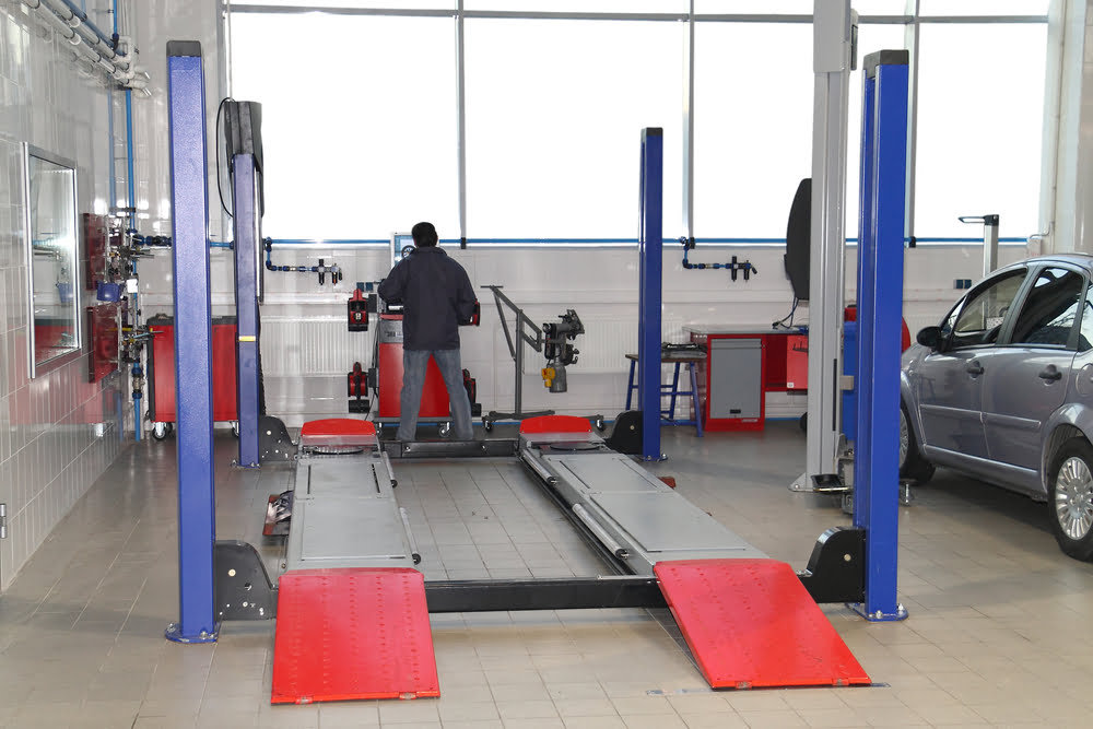 mechanic standing next to a newly added car lift